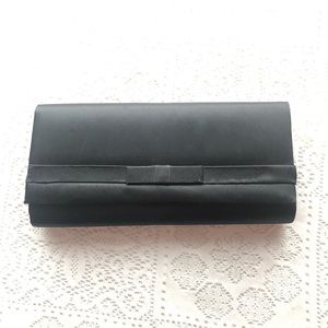 Black clutch purse with front bow embellishment